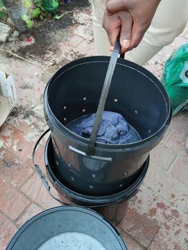Slowly pulling out the inner bucket to keep the laundry water in the outer bucket